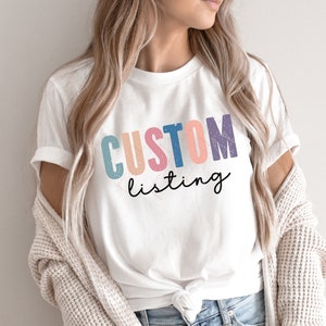 May include: White t-shirt with the text "CUSTOM listing" in colorful letters with a distressed look.