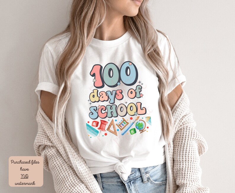 K&ouml;nnte beinhalten: Wei&szlig;es T-Shirt mit einer bunten Grafik, auf der "100 Tage Schule" steht, umgeben von Schulutensilien.