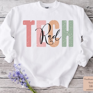 May include: White sweatshirt with the text "Tech Rad" in colorful block letters with a distressed effect.