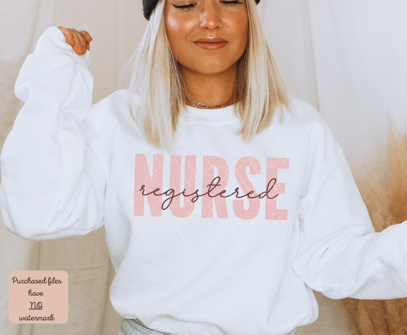 Puede incluir: Sudadera blanca con un gr&aacute;fico rosa que dice "NURSE registered" en una fuente desgastada.
