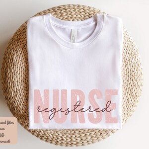 Puede incluir: Camiseta blanca con el texto "NURSE registered" en rosa con textura brillante.