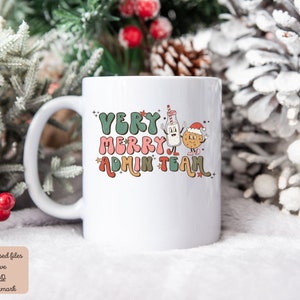 May include: White ceramic mug with a Christmas-themed design. The mug features a milk carton and a cookie with faces, wearing a Santa hat. The text on the mug reads "Very Merry Admin Team".