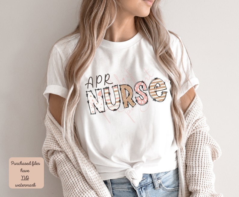 May include: White t-shirt with the text "APR NURSE" in brown and pink letters with a patterned design. The letters are outlined in black and have a stitched look.
