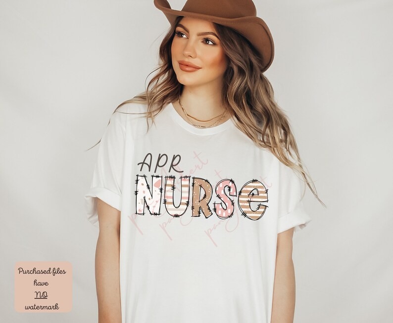 May include: A white t-shirt with the text "APR NURSE" in brown letters with pink and white patterned accents. The letters have a distressed look.
