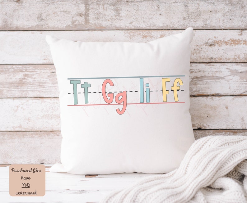 Pu&ograve; includere: Cuscino bianco con un designo alfabetico colorato. Le lettere sono "Tt Gg Li Ff" e sono scritte in un font da bambino. Le lettere sono su una linea con una linea tratteggiata sopra e una linea continua sotto.