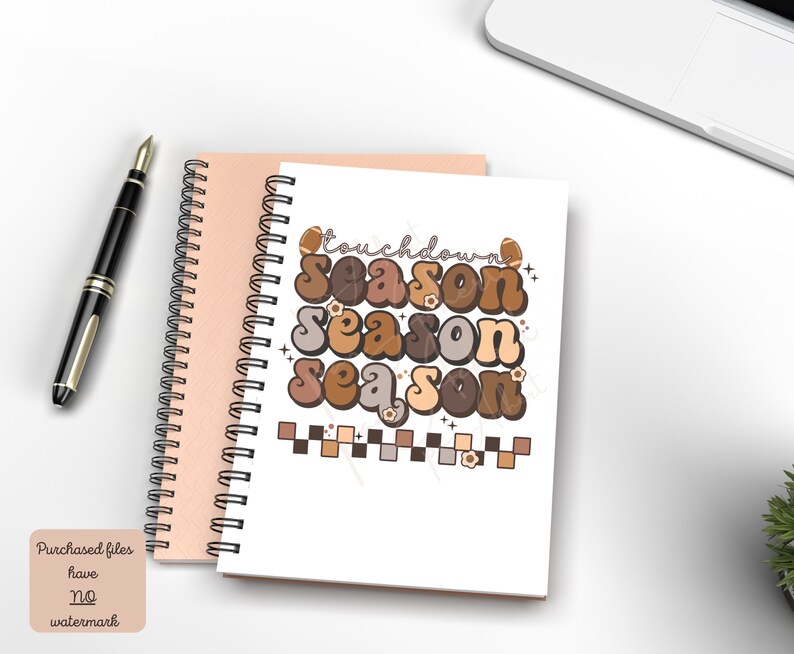 May include: A white notebook with a spiral binding features a brown, orange, and beige graphic design with the text "Touchdown Season" repeated three times. The graphic design includes footballs and flowers.