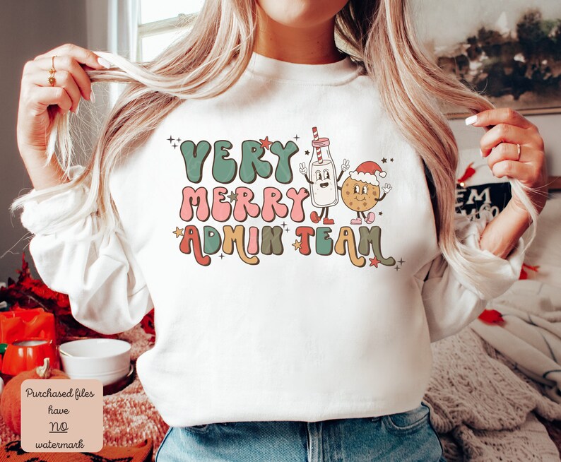 May include: White sweatshirt with a Christmas-themed design. The text reads "Very Merry Admin Team" in a retro font with a milk carton and cookie character.