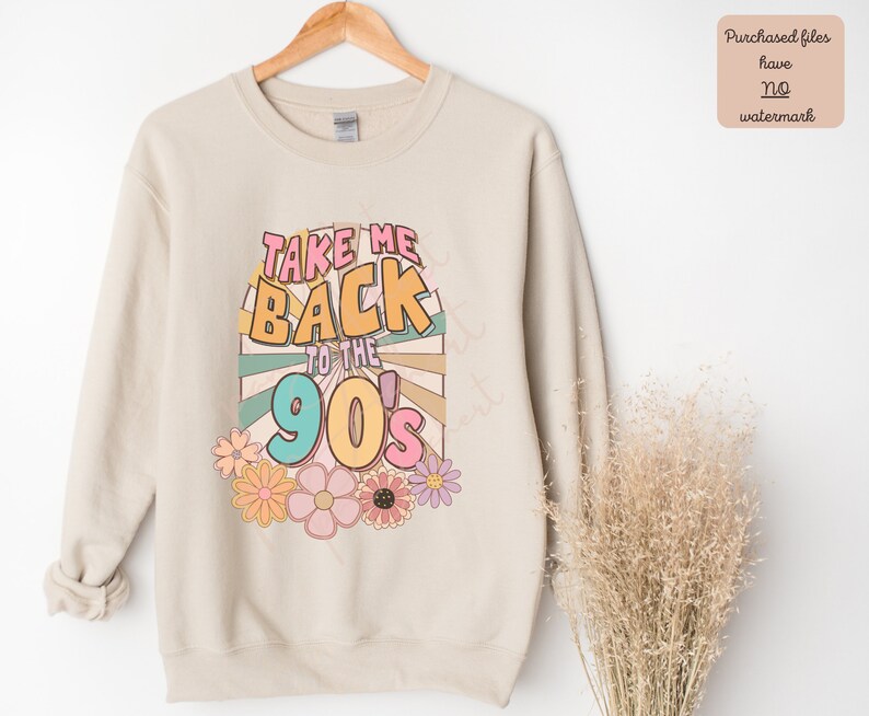May include: A beige sweatshirt with the text "Take Me Back to the 90's" in colorful retro font. The text is surrounded by a colorful sunburst design and flowers.