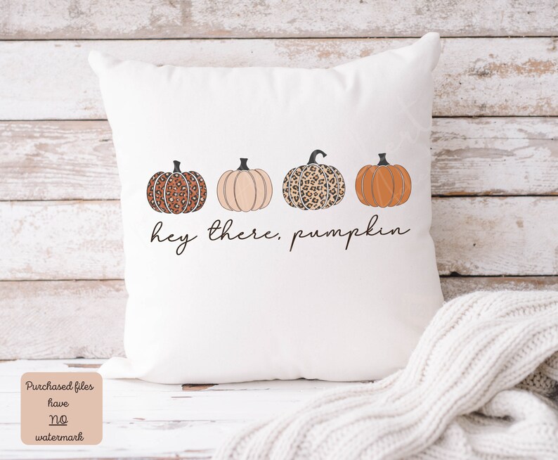 May include: White throw pillow with a graphic of three pumpkins. The pumpkins are orange, beige, and brown with a leopard print. The text "hey there, pumpkin" is printed below the pumpkins.
