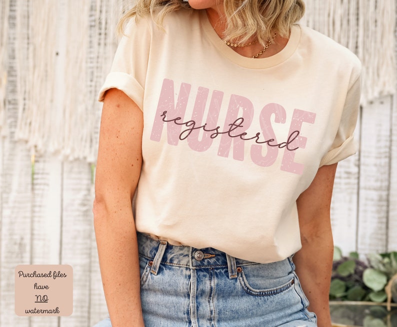 Puede incluir: Una camiseta beige con el texto "NURSE registered" en rosa con un aspecto desgastado.