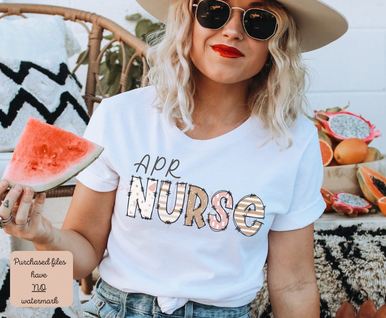 May include: White t-shirt with the text "APR NURSE" in colourful patterned letters. The letters are decorated with pink, brown and white stripes and polka dots.