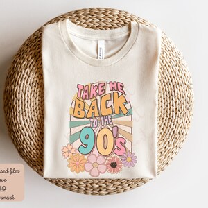 May include: A white t-shirt with a colorful graphic that says "Take Me Back to the 90's". The graphic is in a retro style with a sunburst design and flowers.
