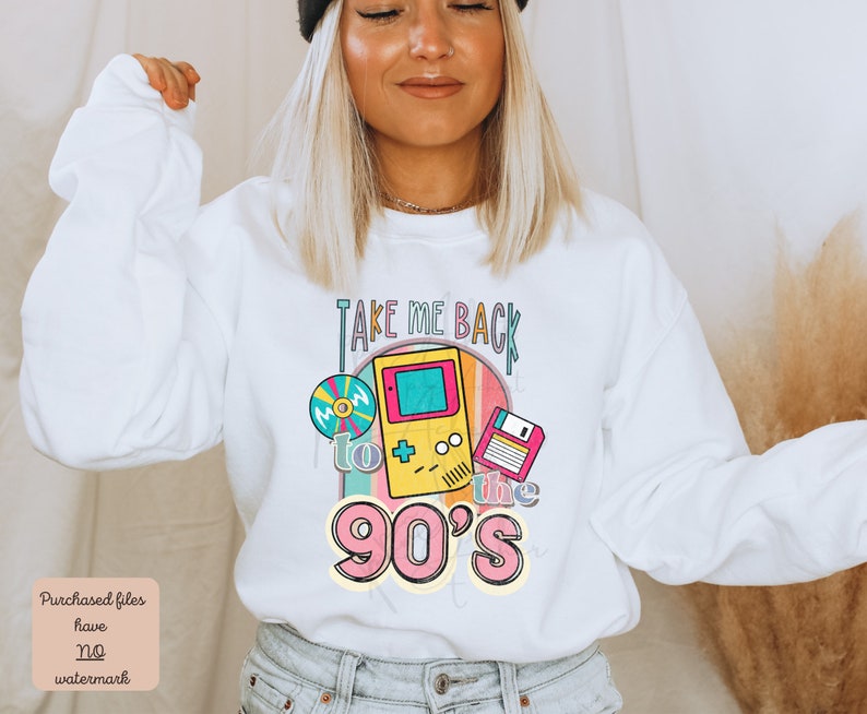 K&ouml;nnte beinhalten: Wei&szlig;er Pullover mit einem bunten Grafikdesign, auf dem "Take me back to the 90's" steht. Die Grafik enth&auml;lt ein Kassettenband, eine Videospielkonsole und eine Diskette.