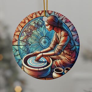 May include: Round ceramic ornament featuring a woman working at a pottery wheel. The image has a stained-glass style with vibrant colors, including blue, orange, and red. The background includes a floral design. A gold string is attached for hanging.