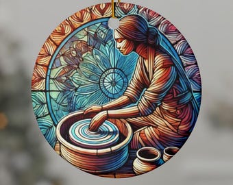 Può includere: Ornamento rotondo in ceramica raffigurante una donna al tornio. L'immagine è in stile vetrata, con colori vivaci come blu, arancione e rosso. Lo sfondo presenta un motivo floreale. Un cordino dorato è attaccato per appenderlo.