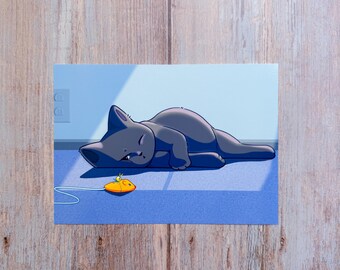 May include: Illustration of a gray cat lying down on a blue surface, with a yellow toy mouse nearby. The cat is in a relaxed pose, and the scene is bathed in soft light, creating a peaceful atmosphere.