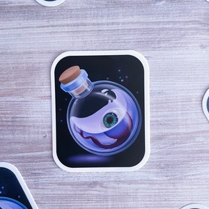 May include: A glass bottle with a cork stopper filled with a swirling purple liquid and a single green eye. The bottle is on a black background with white stars.