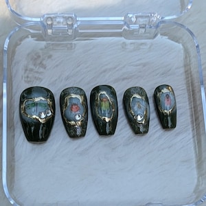 May include: Five dark green coffin-shaped fake nails with gold trim and different insect designs. The designs include a dragonfly, a ladybug, a beetle, a bee, and a butterfly.