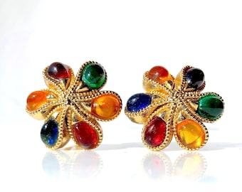 Könnte beinhalten: Ein Paar goldfarbene Ohrringe mit einem Blumenmuster. Jeder Ohrring hat sieben farbige Steine in Tropfenform. Die Steine sind rot, orange, gelb, grün und blau.