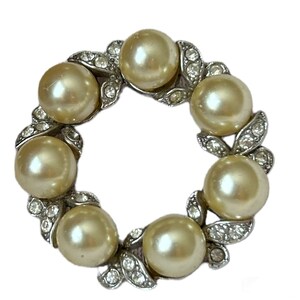 Peut inclure: Une broche en argent et en perles de culture en forme de couronne. La couronne est faite de perles de culture et de strass.