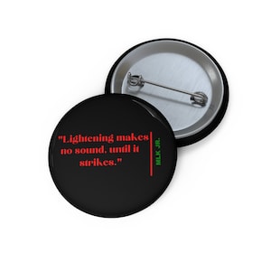 May include: Black button with a red quote by Martin Luther King Jr. that reads "Lightening makes no sound, until it strikes."