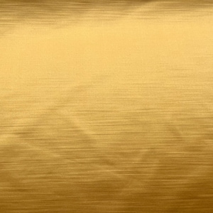 May include: Close-up of a gold-coloured, brushed metal surface. Fine, horizontal lines create a subtle pattern. The lighting highlights the metallic sheen, giving a sense of luxury and quality. The surface has a smooth texture.