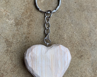 May include: A wooden heart-shaped keyring with a silver chain and ring.