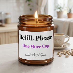 Puede incluir: Una vela encendida en un frasco de vidrio marrón con una etiqueta blanca que presenta el texto negro Refill, Please y el texto morado One More Cup, junto con el texto Fashion Brings Smiles, Boutique Candles 255g Soy Candle.