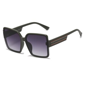 May include: Dark green square sunglasses with gradient lenses. The frames have a thick, angular design. The temples feature a decorative stripe with small rivets. A stylish accessory for eye protection.