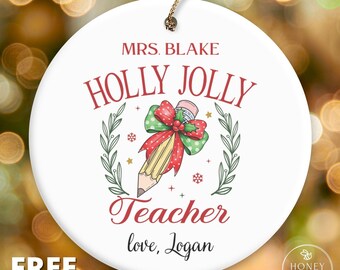 May include: A round white ceramic ornament featuring the text MRS. BLAKE, HOLLY JOLLY, Teacher, and love, Logan. The design includes a yellow pencil tied with a red and green polka dot bow, framed by green leafy branches and small stars.