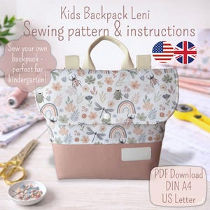 Könnte beinhalten: Ein Schnittmuster für einen Kinderrucksack mit Anleitung. Die Tasche hat eine Klappe mit floralem Druck mit Insekten, Regenbogen und Libellen sowie eine einfarbige rosa Basis. Der Text auf dem Bild lautet "Kids Backpack Leni Sewing pattern & instructions".