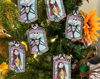 Puede incluir: Un conjunto de ocho adornos para el árbol de Navidad con personajes de la película Pesadilla antes de Navidad. Los adornos son rectangulares y tienen un fondo morado con un borde blanco. Los personajes son Jack Skellington y Sally.