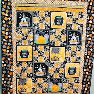 Pode incluir: Um edredom com tema de Halloween com um esquema de cores preto, laranja e branco. O edredom apresenta blocos quadrados com imagens de abóboras, poção de bruxa, caveiras e lápides. A borda tem um padrão de abóboras.
