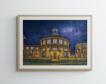 May include: A night photograph of a large, round, stone building with a dome. The building is lit up and has many windows. The sky is dark and filled with stars, including the Milky Way.