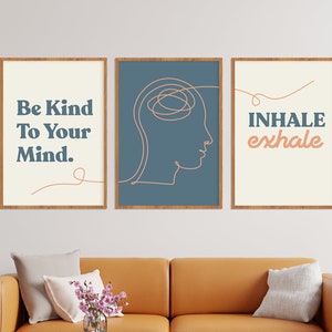 May include: Three framed art prints with inspirational quotes. The first print says "Be Kind To Your Mind." The second print features a line drawing of a head. The third print says "Inhale exhale." All prints have a cream background and are in wooden frames.