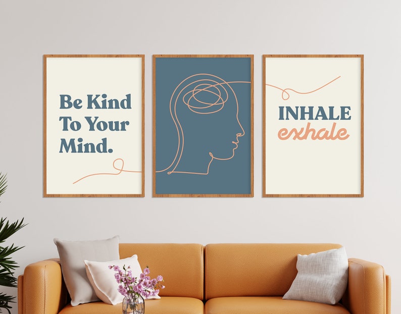 May include: Three framed art prints with inspirational quotes. The first print says "Be Kind To Your Mind." The second print features a line drawing of a head. The third print says "Inhale exhale." All prints have a cream background and are in wooden frames.
