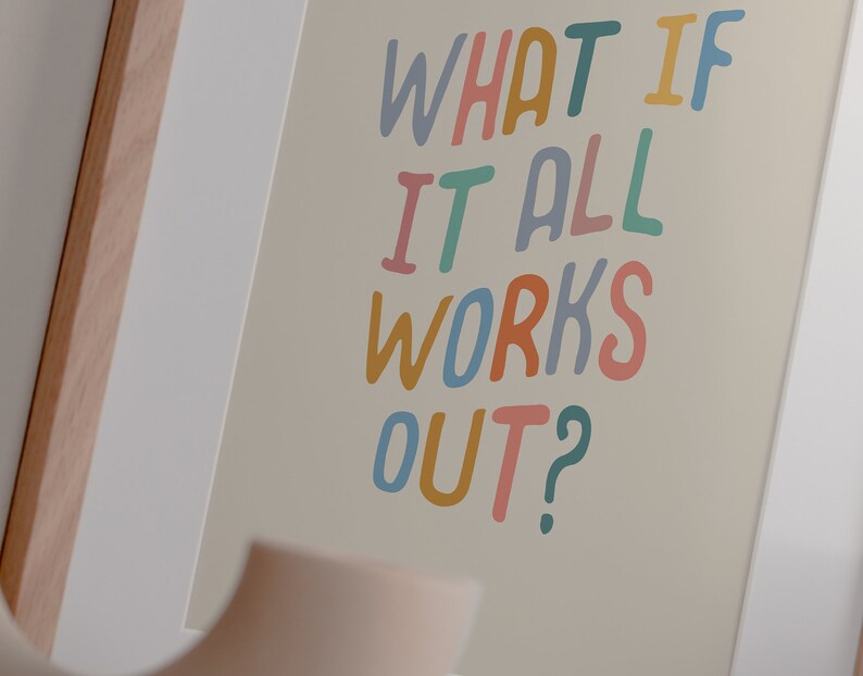 Puede incluir: Una impresi&oacute;n enmarcada con el texto "What if it all works out?" en letras escritas a mano de colores sobre un fondo beige.