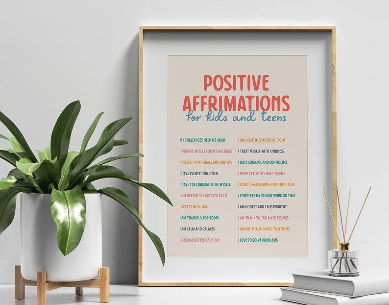 May include: A framed print with the text "POSITIVE AFFIRMATIONS for kids and teens" in red and blue. The print lists positive affirmations such as "I am beautiful inside and out" and "I have courage and confidence". A potted plant and decorative items are in the foreground.
