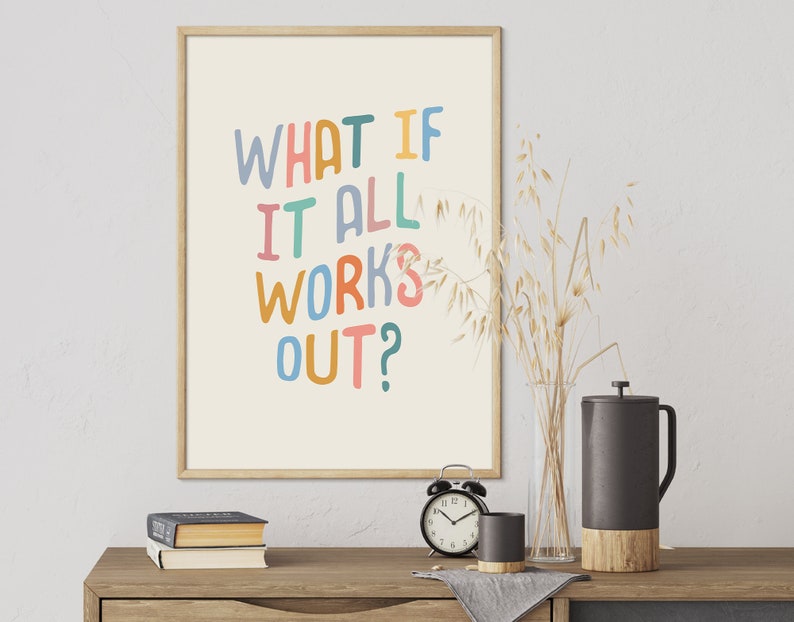 Puede incluir: Una impresi&oacute;n enmarcada con el texto "What if it all works out?" en letras escritas a mano de colores sobre un fondo crema. La impresi&oacute;n est&aacute; colgada en una pared blanca sobre una mesa de madera con un jarr&oacute;n de avena seca, un reloj y una cafetera.