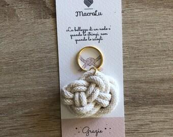 May include: White cotton rope tied into a knot and attached to a gold key ring. The keychain is on a white card with the text "MacraLu" and the Italian phrase "La bellezza di un nodo e quando lo stringi, non quando lo sciogli" and "Grazie".