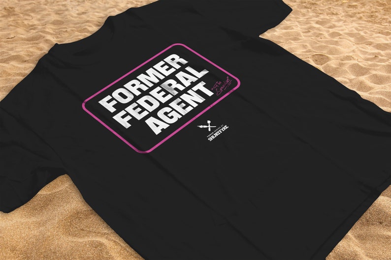 May include: Black t-shirt with a pink rectangle that says "FORMER FEDERAL AGENT" in white text. The text "Ex-Special Agent" is written in cursive in the top right corner of the rectangle. The text "SHORTY FX" is written in white text below the rectangle.