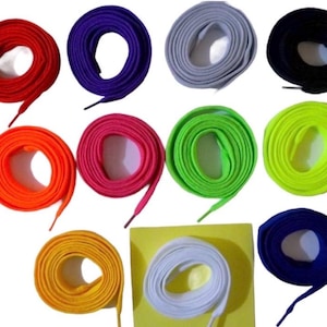 May include: A selection of coiled shoelaces in a spectrum of colours: red, purple, grey, black, orange, pink, green, yellow, white, and blue. The laces are neatly presented, highlighting the range of shades.