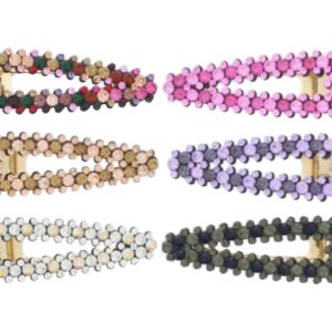 May include: Six colourful hair clips with a rhinestone design. The clips are oval shaped and have a gold metal clasp.