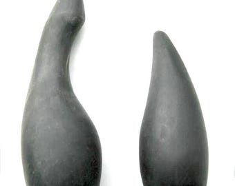 May include: Two black rubber bottle stoppers shaped like a teardrop. The larger stopper is curved and the smaller stopper is straight.