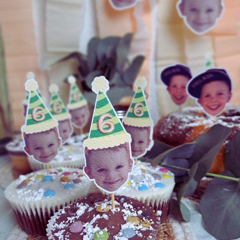 Puede incluir: Primer plano de cupcakes decorados con chispas de colores y coronados con sombreros de fiesta con fotos de ni&ntilde;os y el n&uacute;mero "6".
