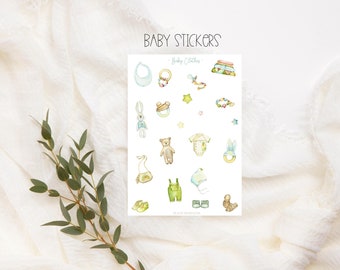 May include: A sheet of stickers featuring illustrations of baby clothes and accessories. The stickers are on a white background with the text "Baby Stickers - Baby Clothes - 18 high quality stickers" at the bottom.