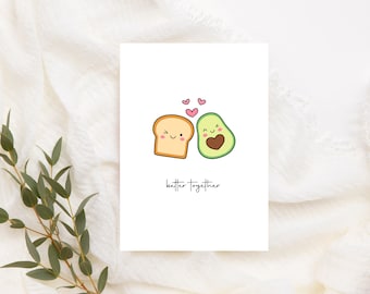 May include: A white card with a cartoon illustration of a slice of bread and an avocado with faces. The bread and avocado are smiling and have hearts above them. The text "better together" is written below the illustration.
