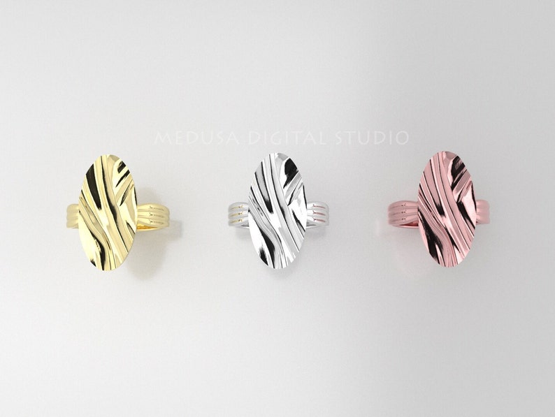 Pu&ograve; includere: Tre anelli ovali con un design testurizzato. Gli anelli sono in oro, argento e oro rosa.