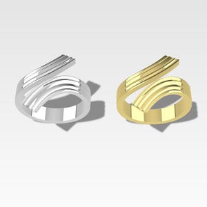 May include: Two rings, one silver and one gold, with a twisted, multi-layered design. The rings are both open and have a simple, modern style.