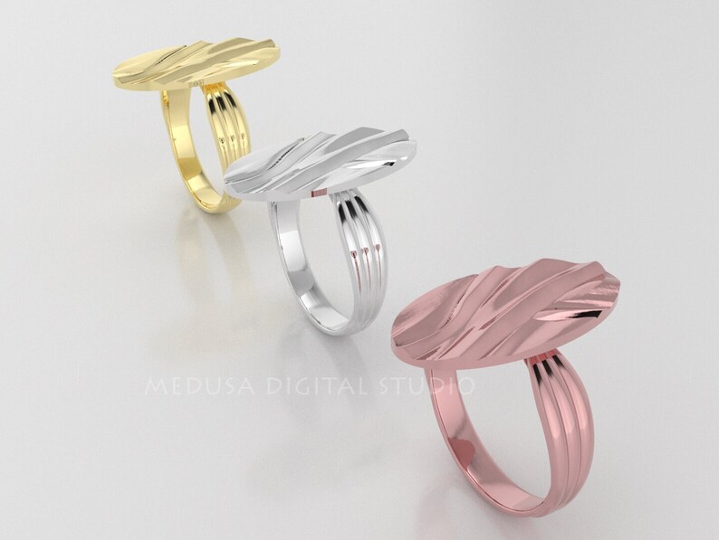 Pu&ograve; includere: Tre anelli ovali con un design testurizzato. Gli anelli sono in oro, argento e oro rosa.